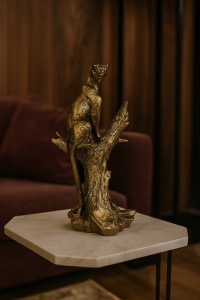 Statuetă panteră elegantă argintie, așezată pe un trunchi de copac, simbol al puterii și grației