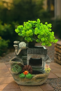fântână feng shui cu pom verde, roată de apă și casă tradițională