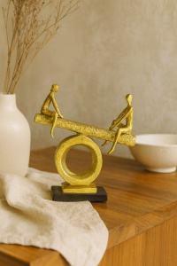 Figurine moderne aurii reprezentând două persoane pe un leagăn stilizat, montat pe suport circular
