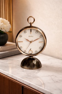 Ceas de masă elegant cu cadran alb, finisaj auriu și bază neagră decorativă