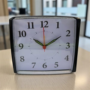 Ceas de masă analogic cu ramă neagra și cadran alb, ideal pentru dormitor sau birou modern
