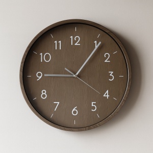 Ceas de perete modern rotund cu cadran maro și cifre albe, design minimalist pentru decor interior