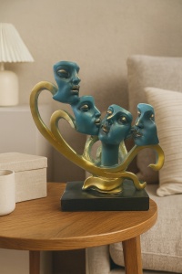 Statuetă abstractă cu patru fețe albastre pe suport auriu, decor artistic modern, simbol al expresiilor