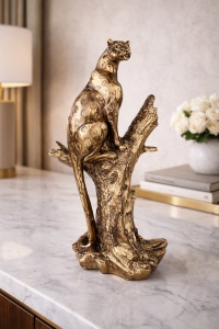 Statuetă panteră elegantă argintie, așezată pe un trunchi de copac, simbol al puterii și grației