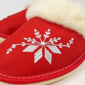 Detaliu broderie ornamentală de iarnă pe exteriorul din piele roșie.