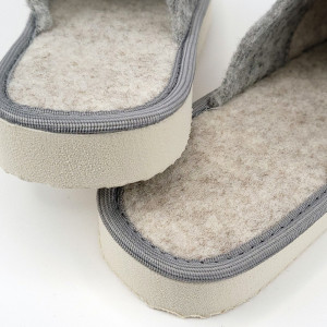 O pereche de papuci de casă din postav gri, cu o broderie florală discretă. Papucii au un design minimalist și elegant, fiind ideali pentru a te bucura de confort și căldură la tine acasă.