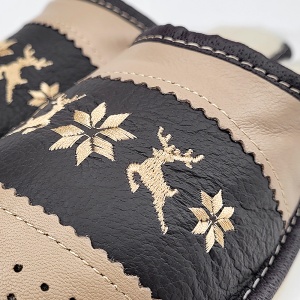 Detaliu broderie nordică cu reni și fulgi, finisaj decorativ elegant