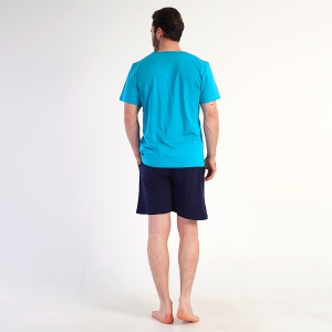 Fotografie cu modelul din spate, prezentând croiala dreaptă a pantalonilor scurți. Se poate observa și elasticul din talie cu snur pentru ajustare.