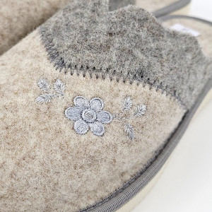O pereche de papuci de casă din postav gri, cu o broderie florală discretă. Papucii au un design minimalist și elegant, fiind ideali pentru a te bucura de confort și căldură la tine acasă.