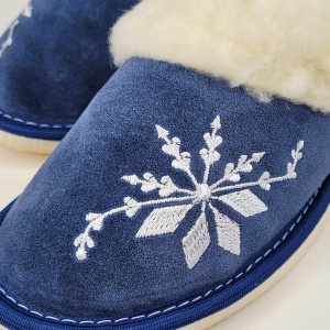Detaliu broderie decorativă și textură catifelată din piele întoarsă albastru denim.