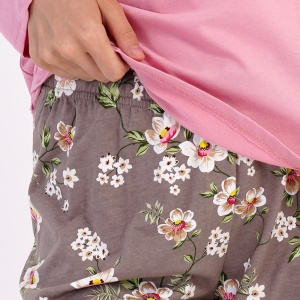 Detaliu cu banda elastică și șnurul reglabil în talie pe pantalonul cu imprimeu floral.