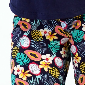 Detaliu pantaloni: imprimeu multicolor vesel cu flori și fructe exotice, prevăzut cu o betelie elastică confortabilă și șnur reglabil.