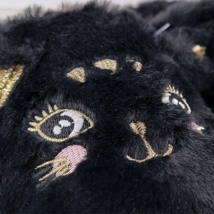 Magie în amănunt. Apropie-te pentru a vedea strălucirea glitterului auriu de pe urechi și detaliile fine brodate care aduc la viață chipul pisicuței 'Black Kitty'.