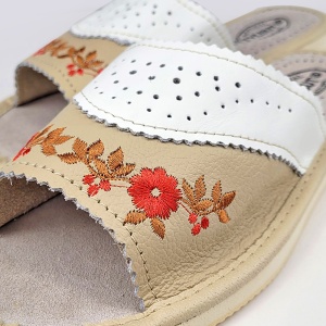 Calitate Tylbut: finisaje impecabile ale motivului floral pe piele naturală crem.