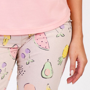 O femeie zâmbitoare purtând pijamaua Vienetta Fruit Summer Pink din bumbac 100%.