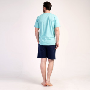 Un bărbat relaxat zâmbind purtând Pijamaua Barbati cu Pantalon Scurt Vienetta, Model Urban Silver Pine.