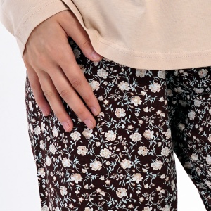 Detaliu cu banda elastică și șnurul reglabil în talie pe pantalonul cu imprimeu floral.