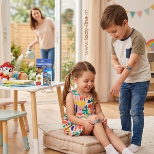 O fetiță și un băiat aplicându-și plasturii Paw Patrol pe genunchi și mână, transformând îngrijirea micilor zgârieturi într-un moment plin de curaj.