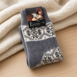 Șosete călduroase din lână 100% Eluna Nordic Winter așezate decorativ pe o pătură moale de iarnă.