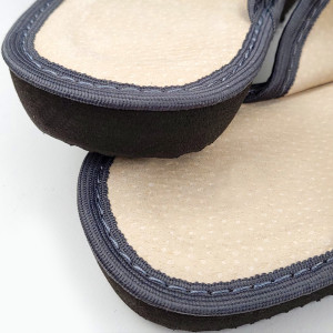 O pereche de papuci de casă din piele gri, model Luxury Woman Dark Grey, cu perforații delicate și talpă groasă.