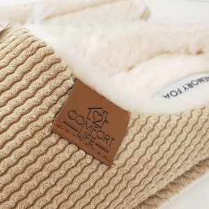 Calitatea în amănunt. Apropiere pentru a aprecia textura fină a catifelei răiate în zig-zag și detaliul superior al patch-ului gravat "Comfort Life" din piele artificială.