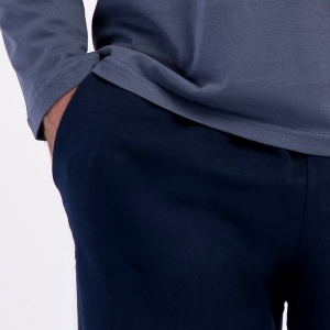 Detaliu cu buzunarul lateral practic și șnurul reglabil din talia pantalonilor lungi uni.