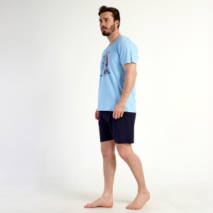 Fotografie cu modelul din lateral, evidențiind croiala lejeră a bluzei și a pantalonilor scurți. Se poate observa și textura moale a bumbacului.