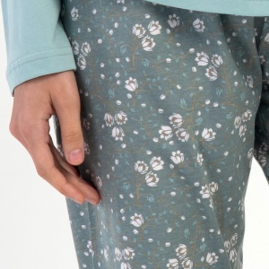 Detaliu cu banda elastică și șnurul reglabil în talie pe pantalonul cu imprimeu floral.