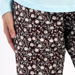 Detaliu cu banda elastică și șnurul reglabil în talie pe pantalonul cu imprimeu floral.