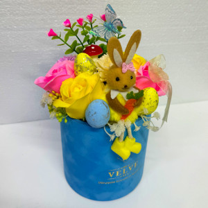 Aranjament floral Easter, decoratiune iepure, 3 oua decorative, plante verzi, trandafiri si garoafe de sapun, in cutie rotunda catifea albastra