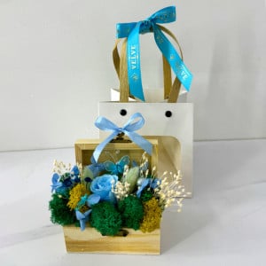 Aranjament floral Goodliness, cu trandafir criogenat, licheni stabilizati, fluture decorativ, perle si broom, in cutie tip cufar, cu funda, Albastru
