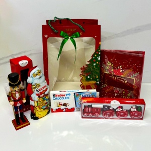 Pachet Merry Christmas, cu figurina Spargatorul de Nuci, Felicitare muzicala de Craciun, ornament trenulet festiv si dulciuri Kinder, ambalate in punga cadou, Rosu