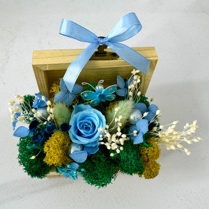 Aranjament floral Goodliness, cu trandafir criogenat, licheni stabilizati, fluture decorativ, perle si broom, in cutie tip cufar, cu funda, Albastru 1