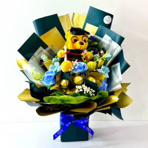 Aranjament floral pentru absolvire, in cutie patrata cu trandafiri, praline Ferrero Rocher, batoane Snickers, ciocolatele Merci, Albastru glaciar