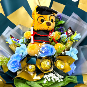 Aranjament floral pentru absolvire, in cutie patrata cu trandafiri, praline Ferrero Rocher, batoane Snickers, ciocolatele Merci, Albastru glaciar