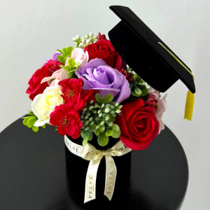 Aranjament floral pentru absolvire, in cutie rotunda cu trandafiri si plante artificiale, rosu
