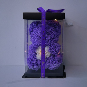 Ursulet floral 25cm, cu LED-uri luminoase, din trandafiri spuma mov cu inima rosie, in cutie cadouUrsulet floral 25cm, cu LED-uri luminoase, din trandafiri spuma mov cu inima rosie, in cutie cadou