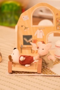 Porcușor de pluș adorabil cu ținută cosy, perfect pentru mâini mici, joc blând și îmbrățișări calde.