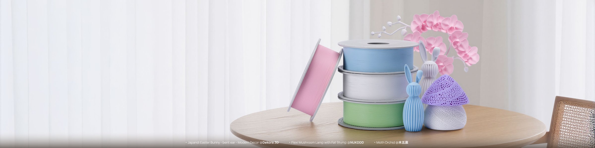 Role de filament Bambu Lab PETG Matte în nuanțe pastelate, alături de iepurași, mușchi de orhidee și o veioză printate 3D