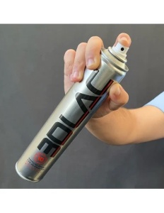 O mână pulverizează spray-ul adeziv 3DLAC din tubul de 400ml pe suprafața de sticlă a unei imprimante 3D, pentru a asigura fixarea pieselor și prevenirea warping-ului.