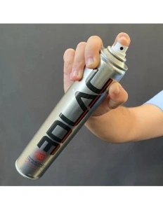 O mână pulverizează spray-ul adeziv 3DLAC din tubul de 400ml pe suprafața de sticlă a unei imprimante 3D, pentru a asigura fixarea pieselor și prevenirea warping-ului.