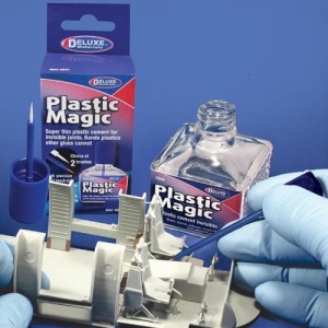 Aplicarea Deluxe Materials Plastic Magic cu pensula pe o structură de macheta din plastic, lângă sticla și cutia originală a produsului