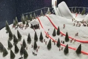 Diorama tematică de iarnă cu figurine, brazi și pistă de sanie, efect de zăpadă creat cu Scenic Snow Kit