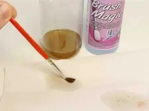 Utilizare Brush Magic — introducerea pensulei în soluție pentru înmuierea vopselei uscate