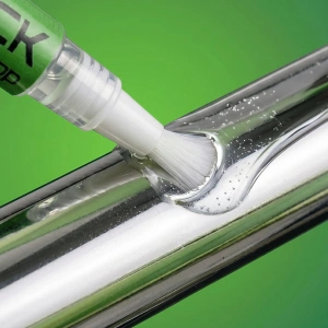 Prim-plan cu pensula OilStick întinzând un strat subțire de ulei pe o tijă metalică