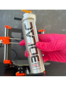 Utilizarea spray-ului adeziv compact 3DLAC Mini de 75ml direct pe suprafața patului încălzit al unei imprimante 3D.
