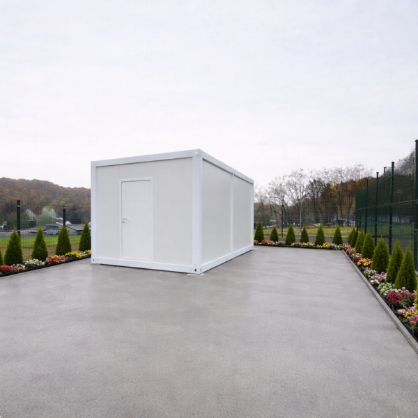 Container alb compact fotografiat din depărtare pe platformă de beton