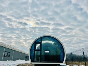 Vedere frontală a capsulei cu geam panoramic albastru pe zăpadă