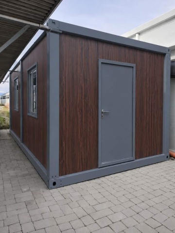 Container cu finisaj lemn închis, ușă gri și fereastră, fotografiat din colț - DenisNetwork