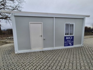 Fațadă de container gri-alb cu ușă plină, fereastră cu grilaj și panou AICI